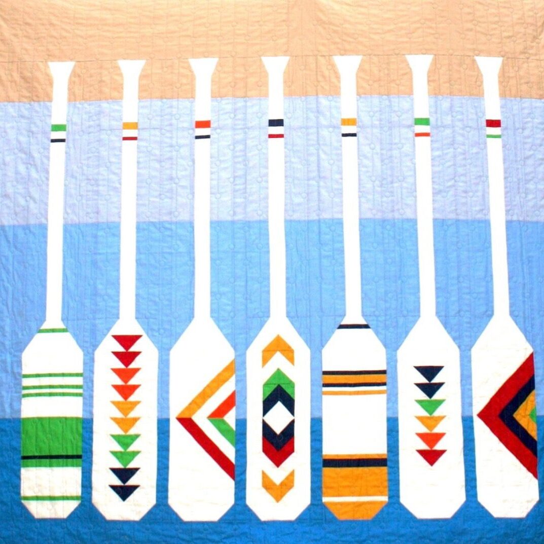 2026 Quilt Raffle Design - multicolored paddles on blue and tan background